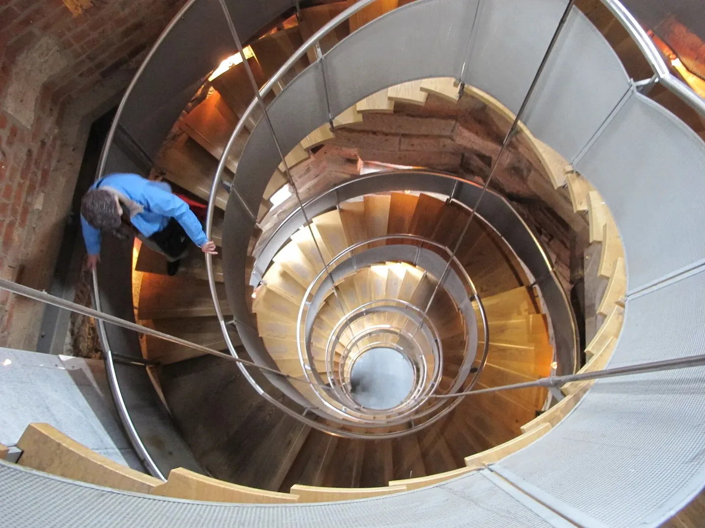 A spiral granite staircase coiling up the inside of a stone lighthouse tower